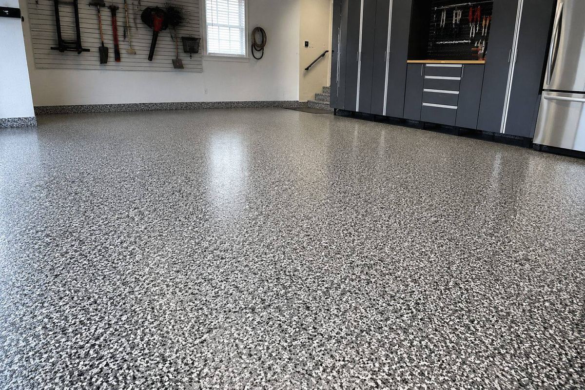 Grey flake epoxy garage floor finish with wall-mounted tool storage